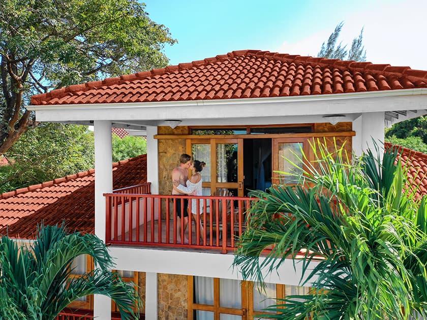 A couple embraces on the balcony of a tropical villa. A couple embraces on the balcony of a tropical villa.
