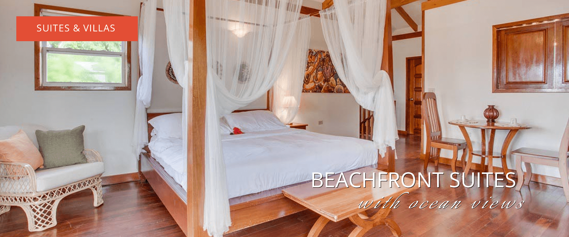 Four poster bed with white coverlet. Wooden furniture and tiled floors. Text says "Suite & Villas" and "Beachfront suites with ocean views"