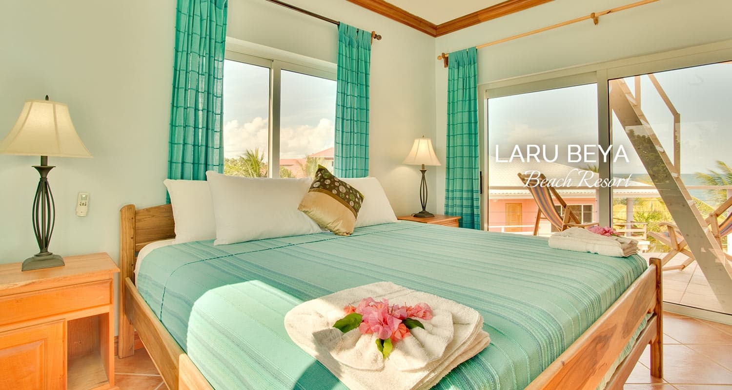 Spacious bedroom at Laru Beya Resort, featuring a king-size bed, ocean view, and tropical decor.