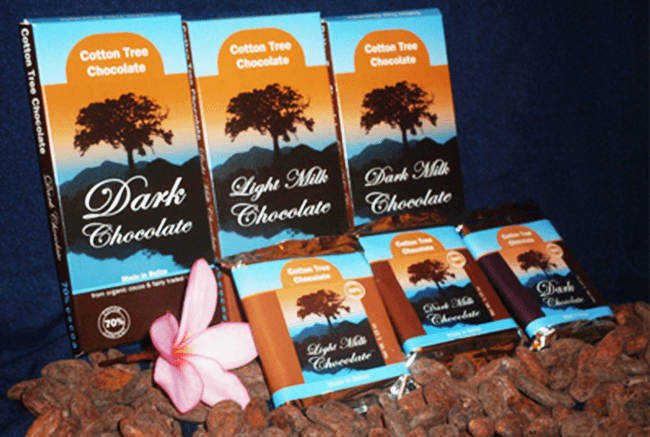 Three types of Cotton Tree Chocolate bars displayed with cocoa beans and a pink flower.