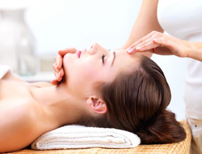 A beautiful brown-haired woman receives a spa facial.