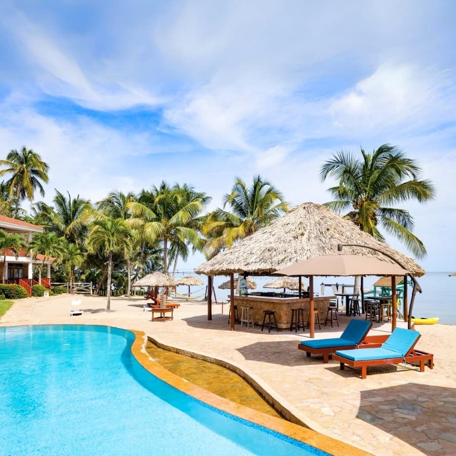 Relax by the pool at a stunning tropical resort. Book your dream vacation now and save $100 with promo code DREAM100.