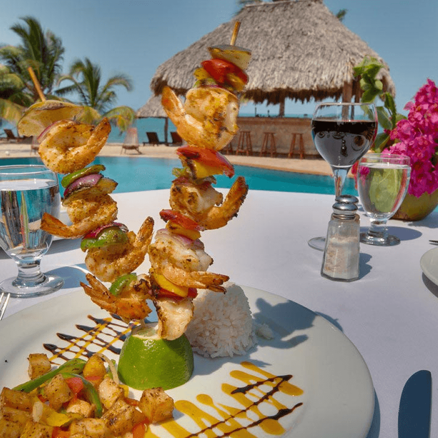 A plate of grilled shrimp skewers served with rice and vegetables.