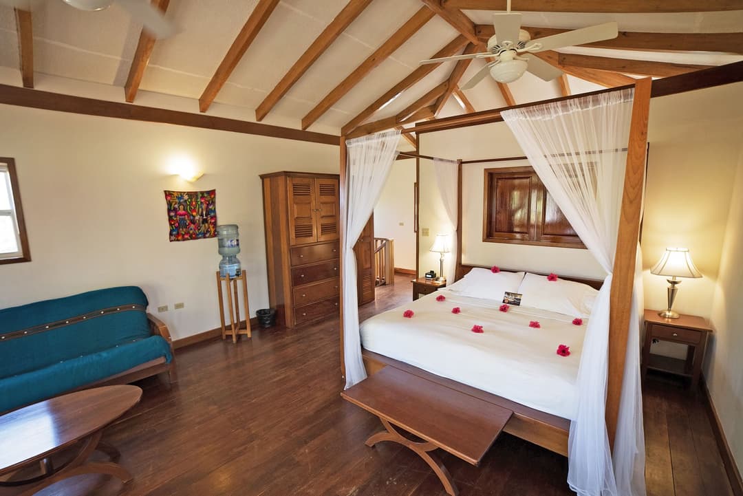 Canopy king bed and sitting area in an oceanfront premium suite
