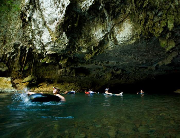 Guests cave tubing through an underground river in Belize