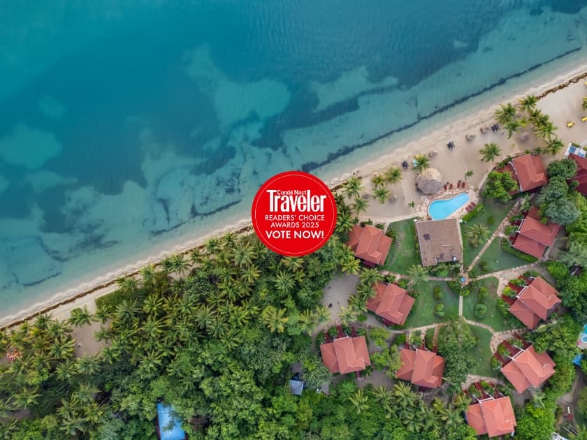 Aerial view of a tropical resort by the beach with a promotional banner for Travel Reader's Choice Awards 2023. Aerial view of a tropical resort by the beach with a promotional banner for Travel Reader's Choice Awards 2023.