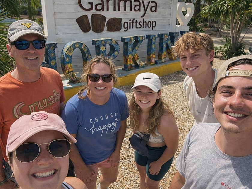 A group of five smiling people poses for a selfie in front of a gift shop sign in Hopkins.
