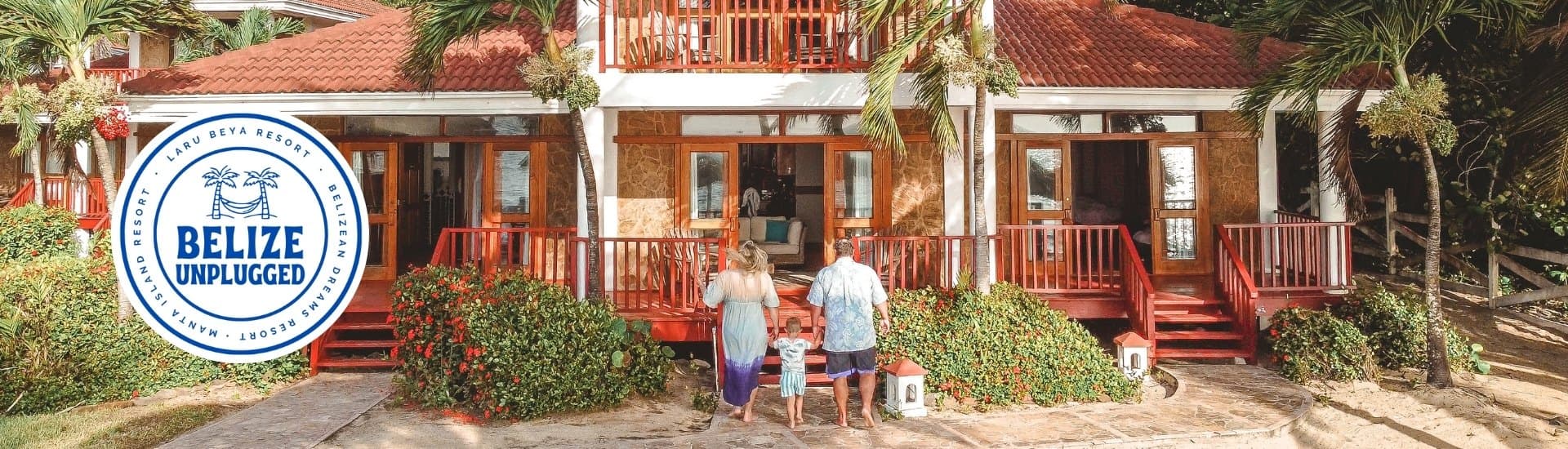 A couple walks towards a charming beach resort with a logo for "Belize Unplugged" in the corner.