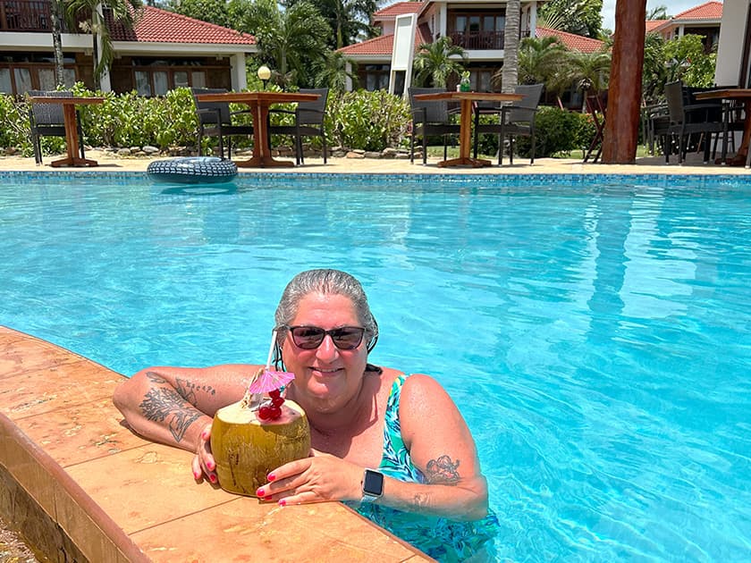 Woman sipping beverage by the pool.